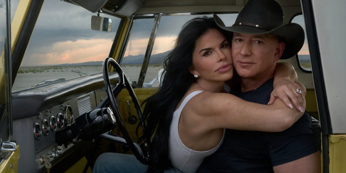 Jeff Bezos dressed in a cowboy hat and trophy wife, in a pickup truck he most certainly has never worked on.